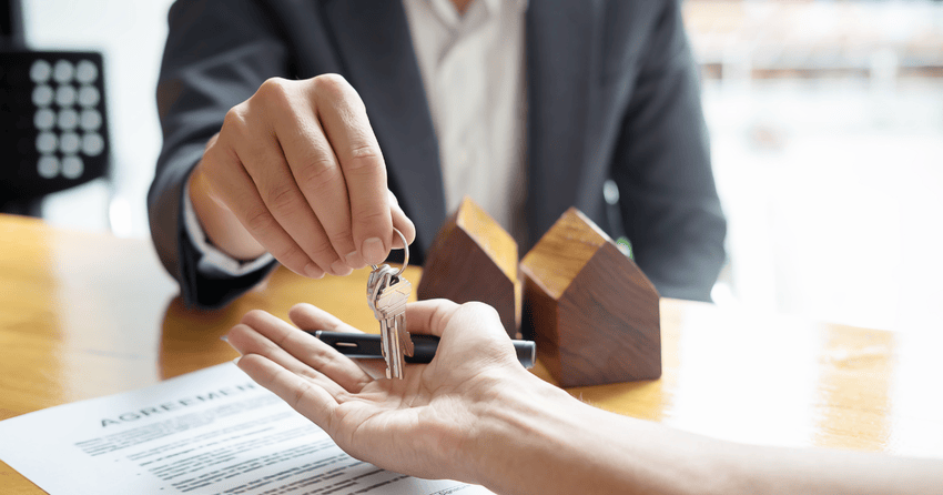 A man handing home keys to new owner.