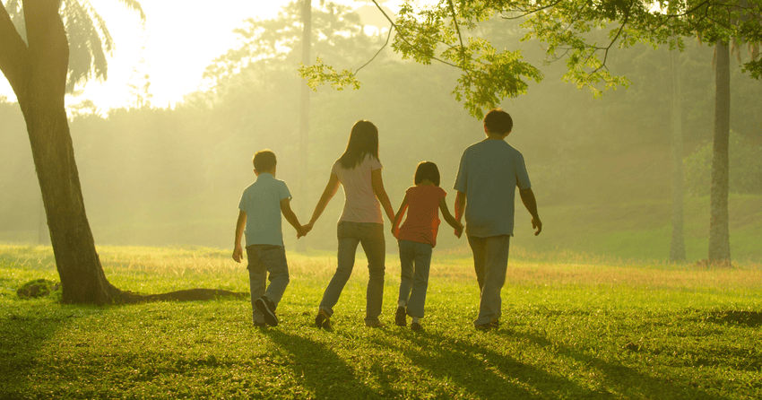 A family walking together through a sunny park, representing the cost of living in Cape Girardeau and the city's family-friendly lifestyle, affordable living, and high quality of life.